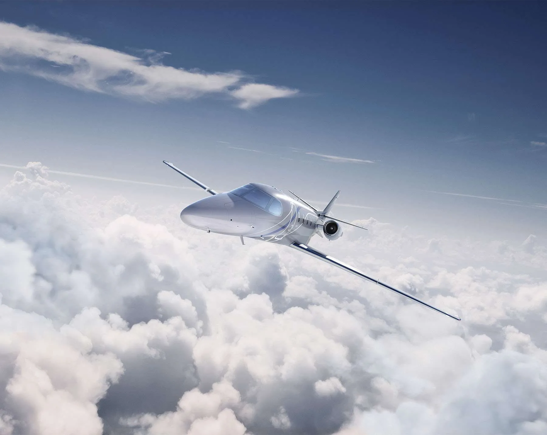 A silver business jet flying above the clouds.