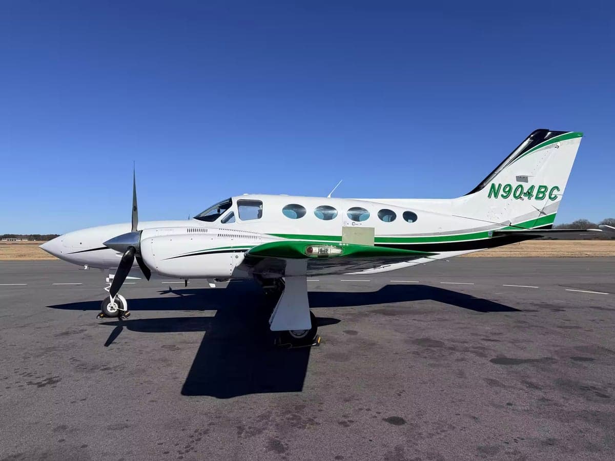 Side view of a white and green Cessna 414 Chancellor, registration N904BC, on the tarmac.