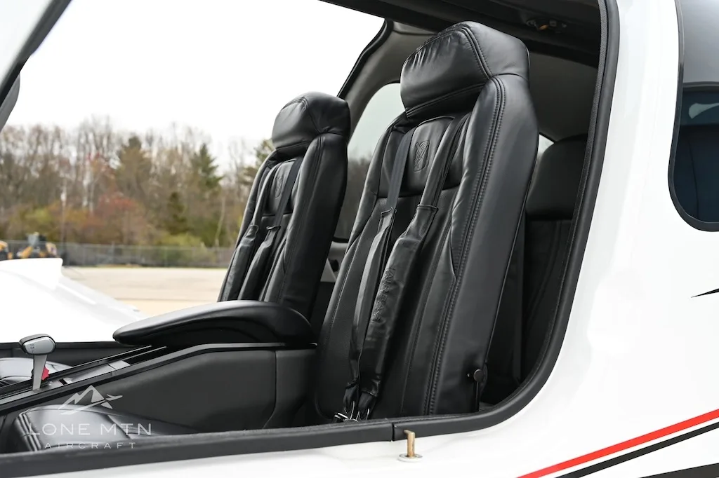 View of the black leather front seats inside a Cirrus SR22 aircraft cabin.