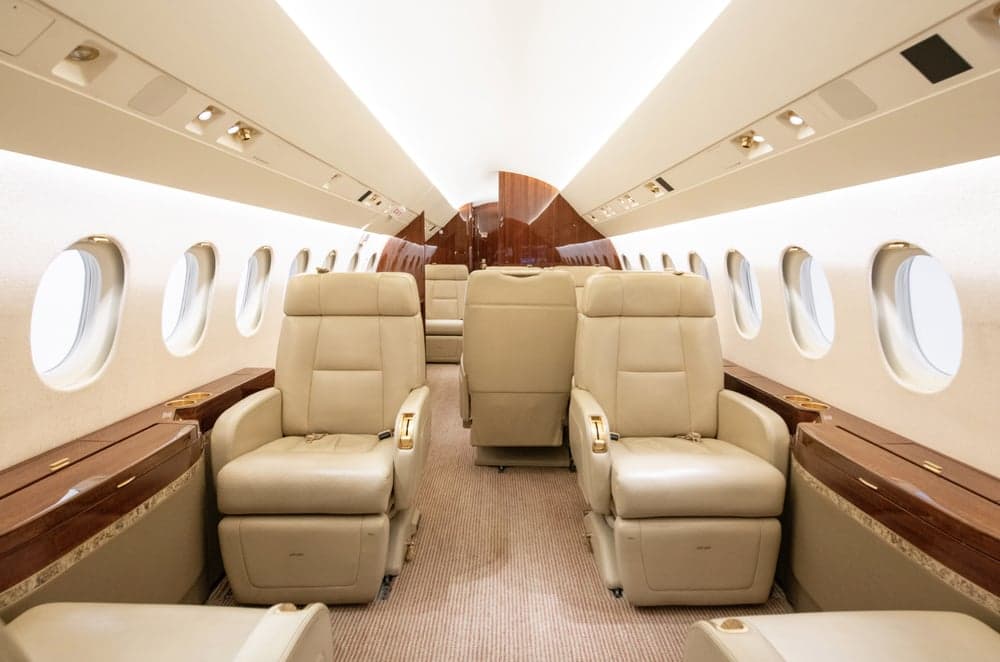Interior view of the aircraft cabin with beige leather seats.