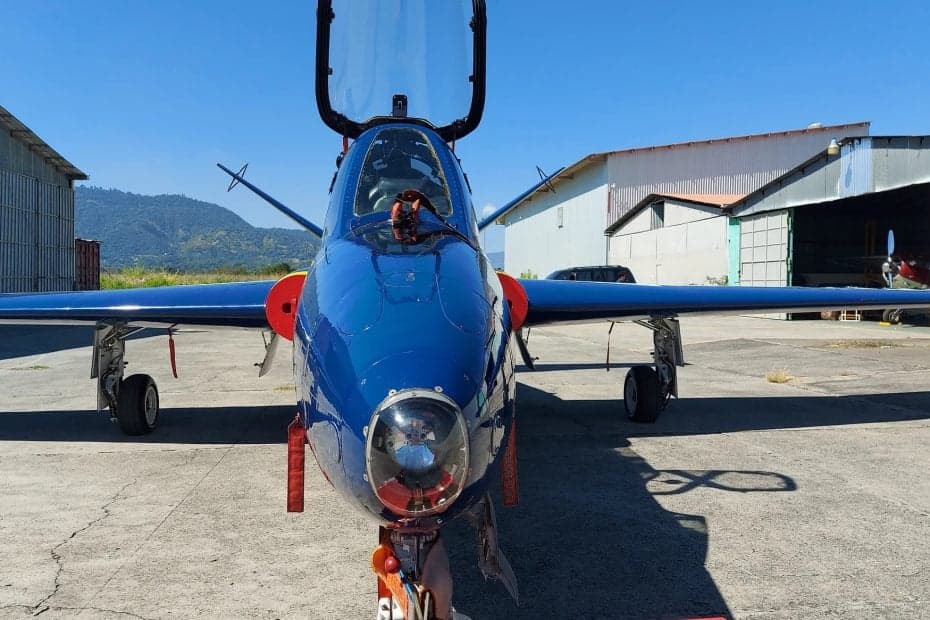 Front view of a blue SIAI-Marchetti S.211 jet on the ground.