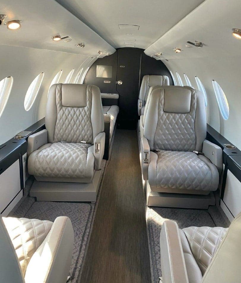 Cabin interior with leather seats and carpet.