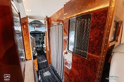 A view of the interior of a jet aircraft, looking towards the cockpit.