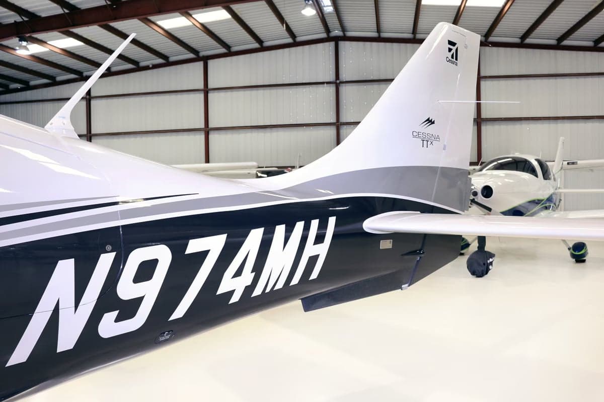 Close-up of the propeller and nose of a Cirrus SR22T aircraft inside a hangar.