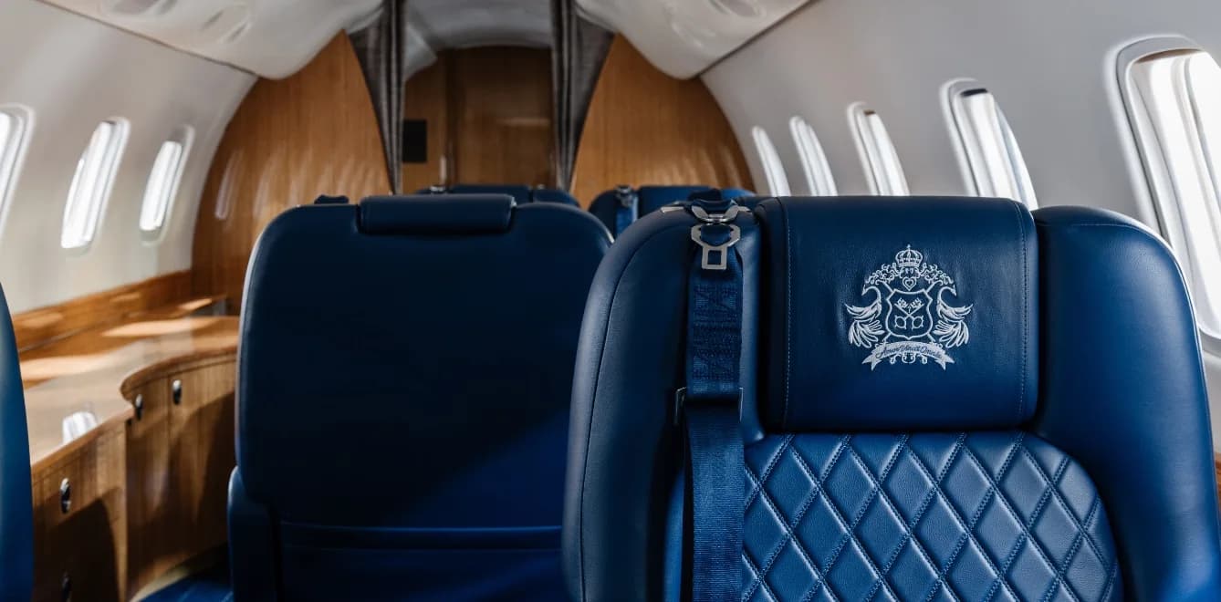 View of the aircraft cabin with blue leather seats and wood paneling.