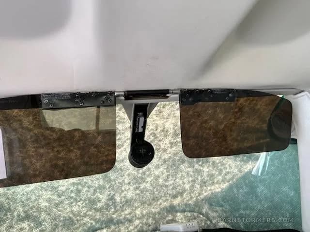 Two brown sun visors are extended above the windshield in the aircraft's cockpit.
