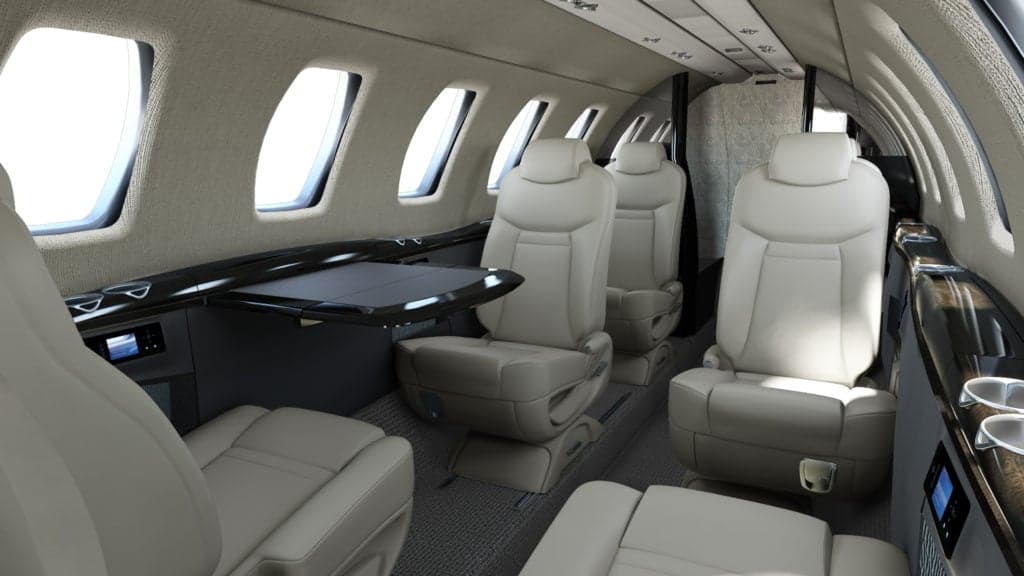The interior of a Citation CJ4 aircraft with beige leather seats.
