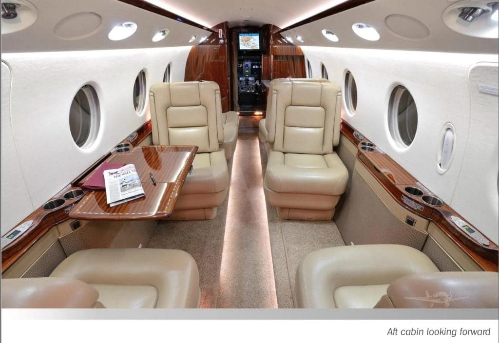 The aft cabin is shown looking forward, with leather seats and wood accents.