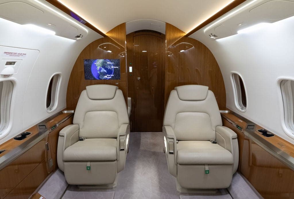 View of the aircraft's interior with two cream-colored leather seats.