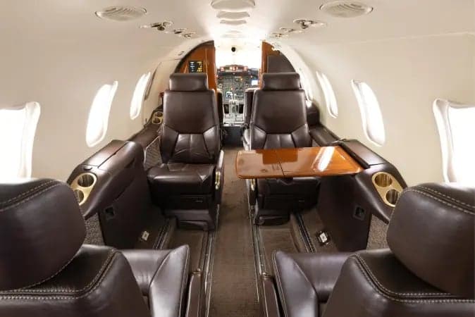 Interior view of the Learjet 45XR cabin with leather seats and tables.