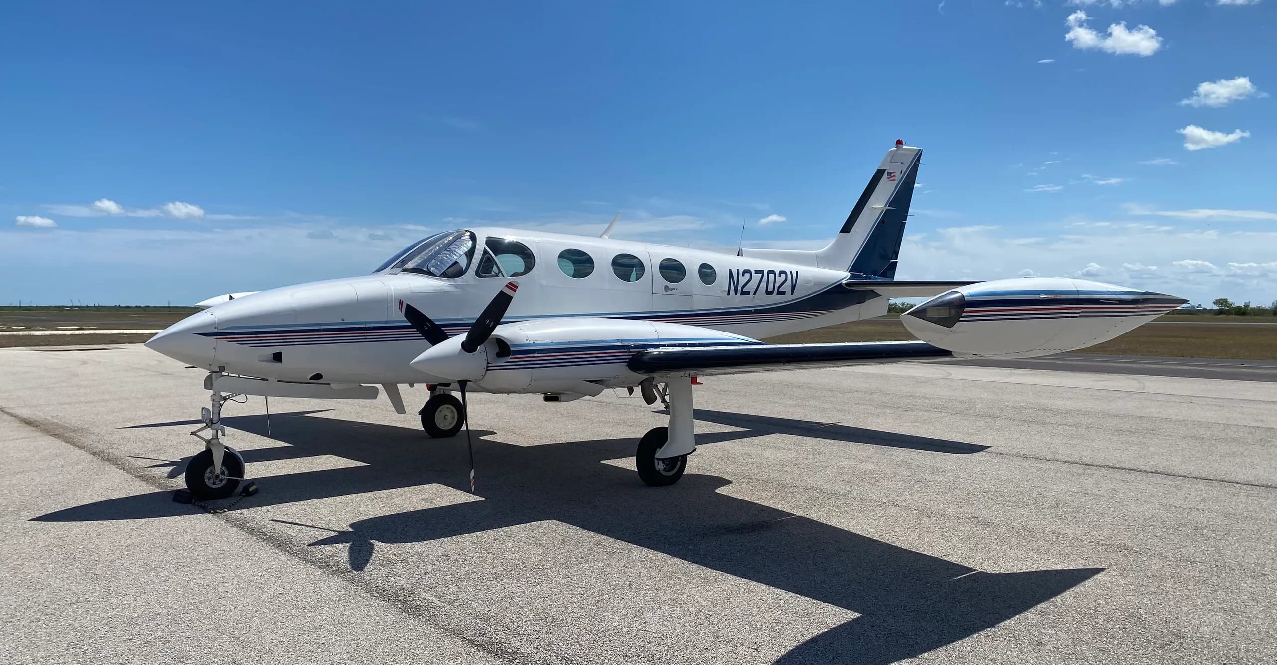A Cessna 340A aircraft with registration N2702V parked on the tarmac.