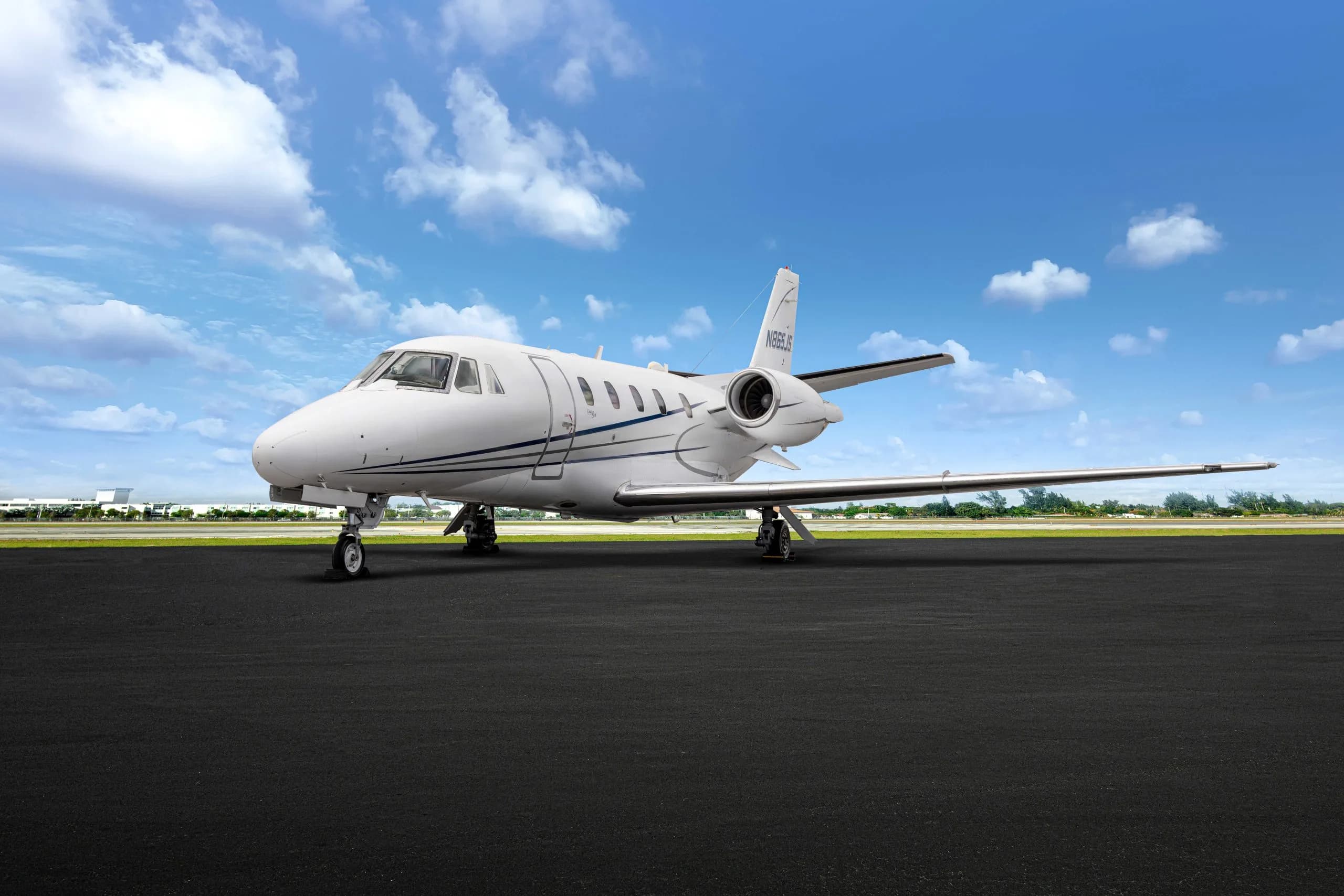 A white aircraft with blue stripes parked on the tarmac.