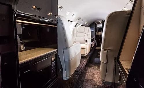 Interior view of the aircraft cabin with seats and a microwave.