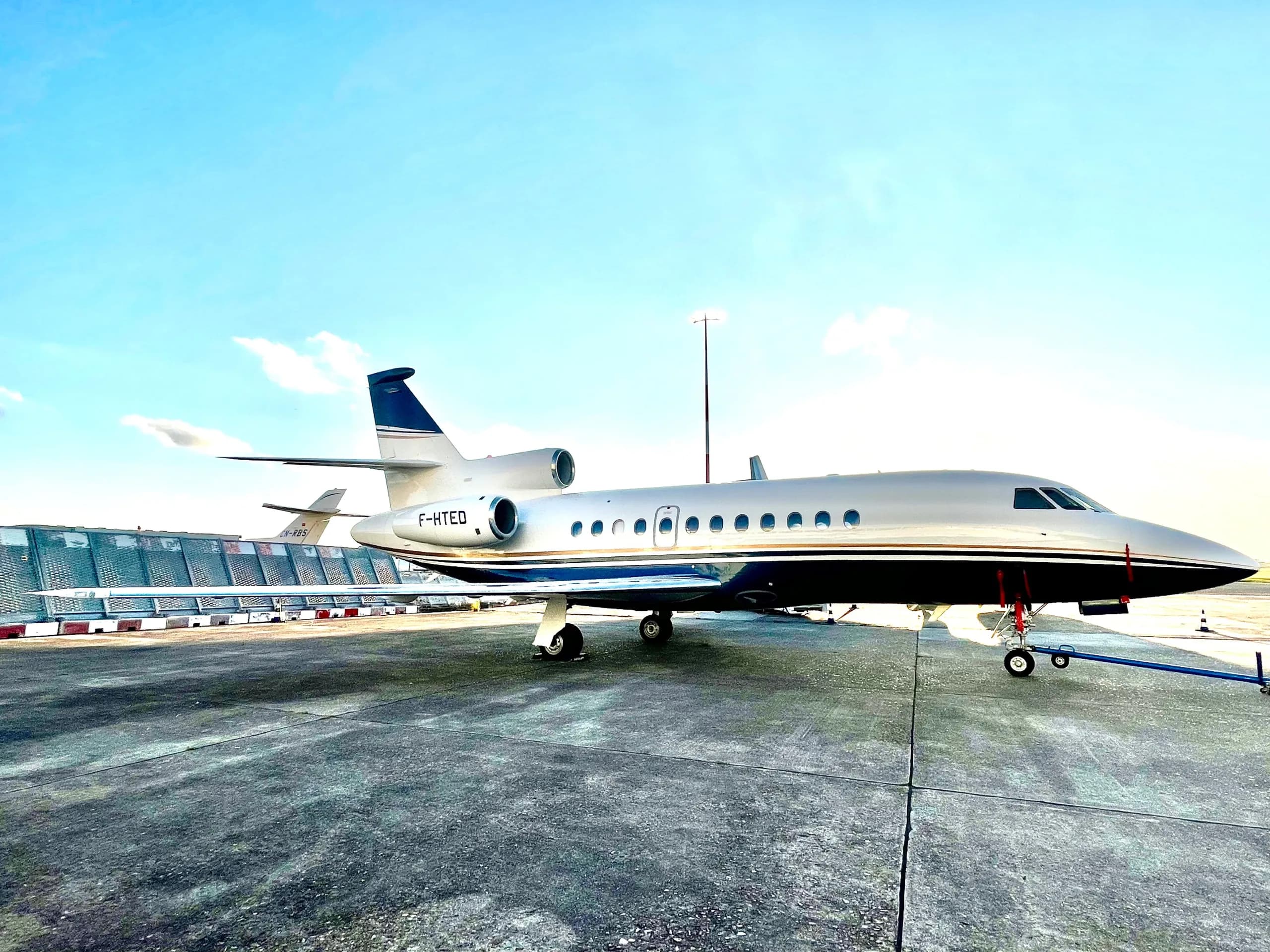 A silver and blue aircraft parked on the tarmac.