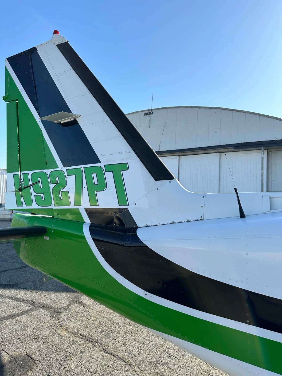 Close-up of the tail of N927PT with green and black stripes.