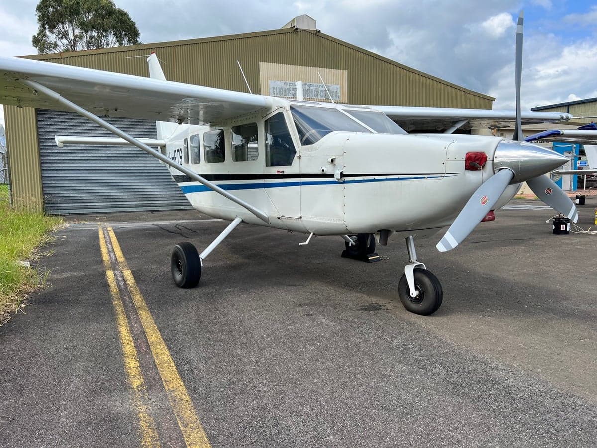 A white Cessna 206 Turbo Stationair aircraft parked on the tarmac.