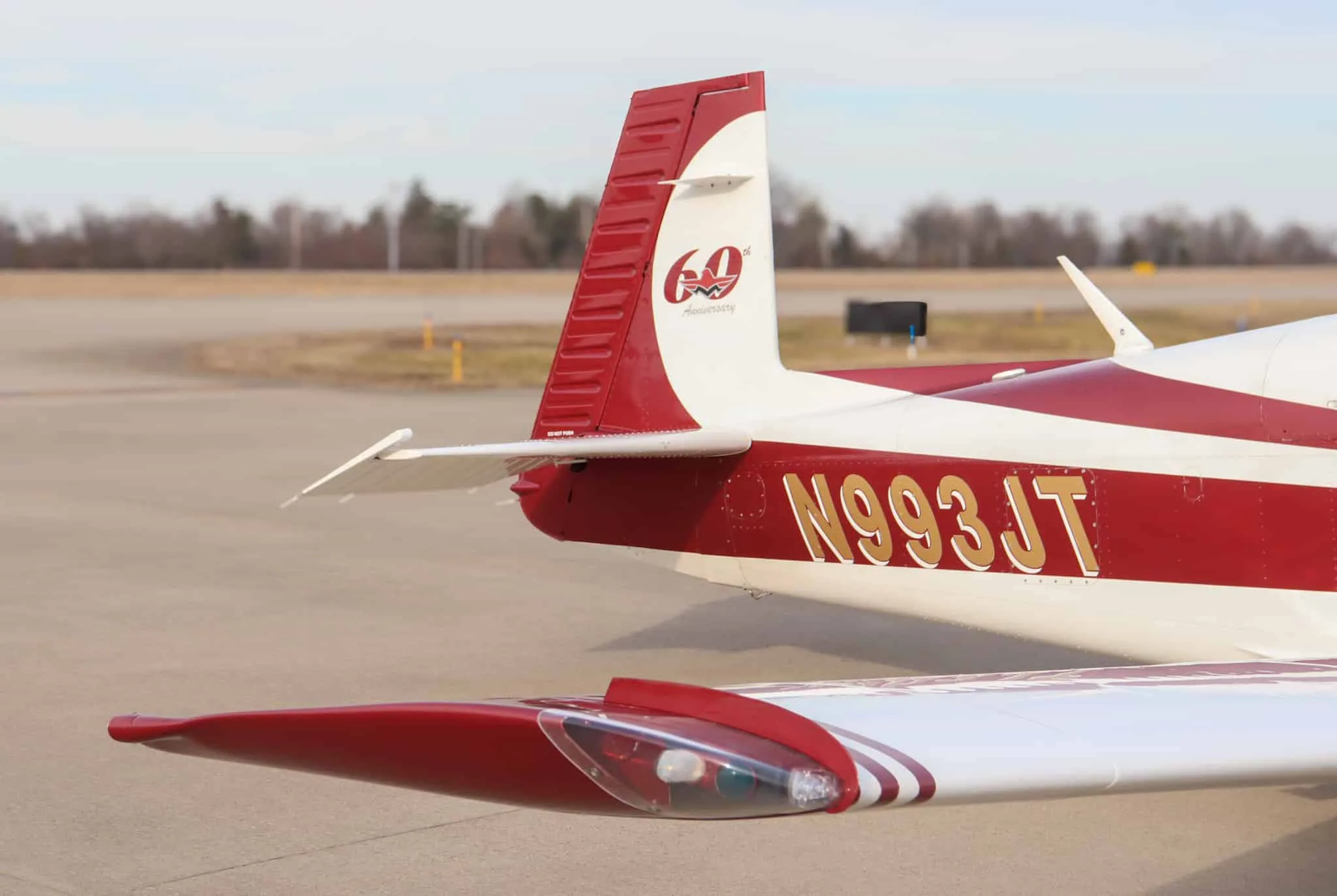Close-up of the tail section of the white and red aircraft, N993JT, showing the 60th Anniversary logo.
