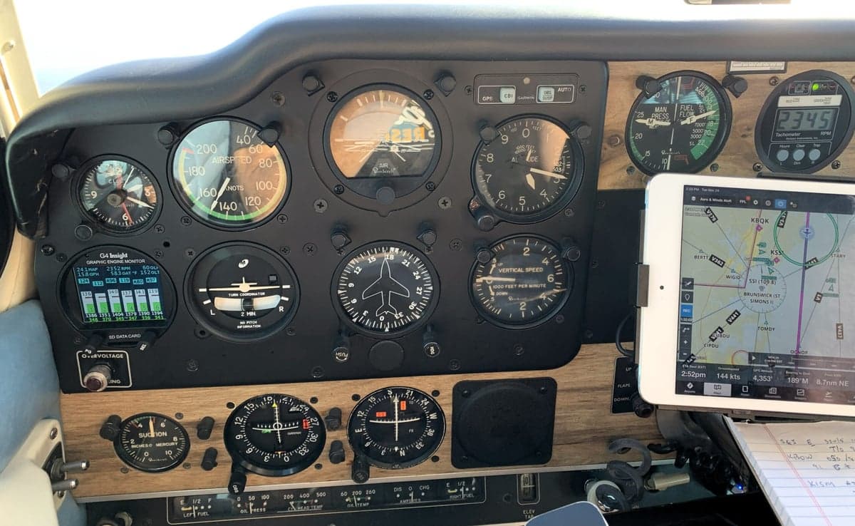 Close-up of the aircraft's instrument panel showing various gauges and a tablet displaying navigation information.