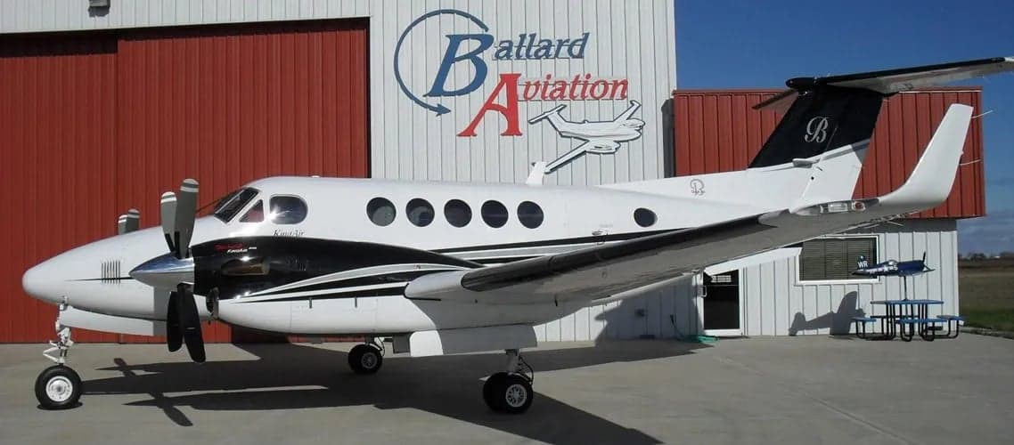 Beechcraft King Air B200 aircraft parked in front of a hangar.
