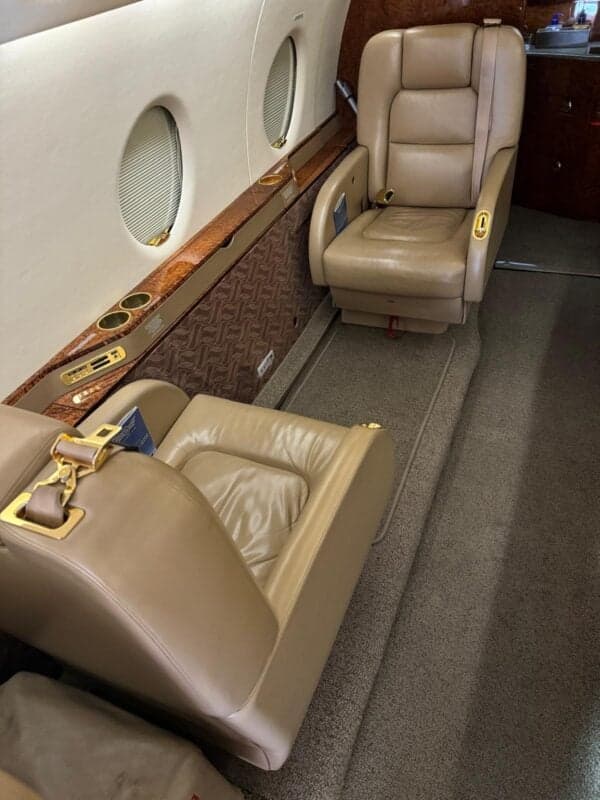 A view of the aircraft cabin seating with tan leather upholstery.