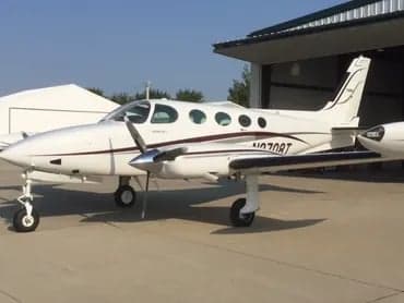 A Cessna 421C Golden Eagle aircraft with registration N2708T parked outside a hangar.