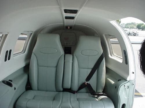 The rear interior of the aircraft with light gray leather seats.