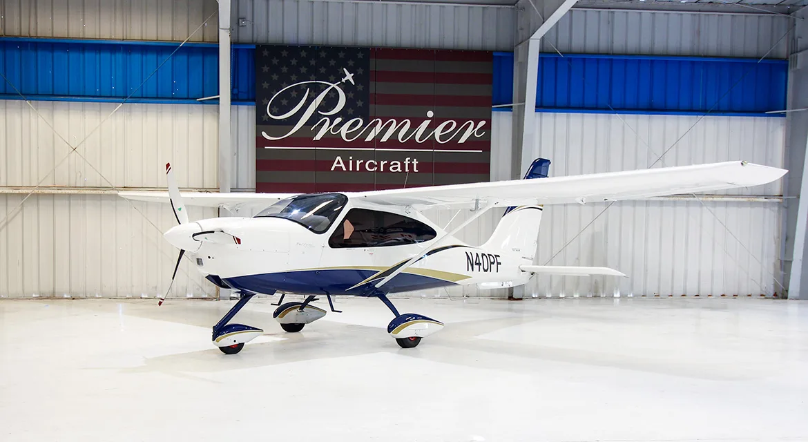 A Techman aircraft with registration N40PF is parked in a hangar with a Premier Aircraft banner in the background.
