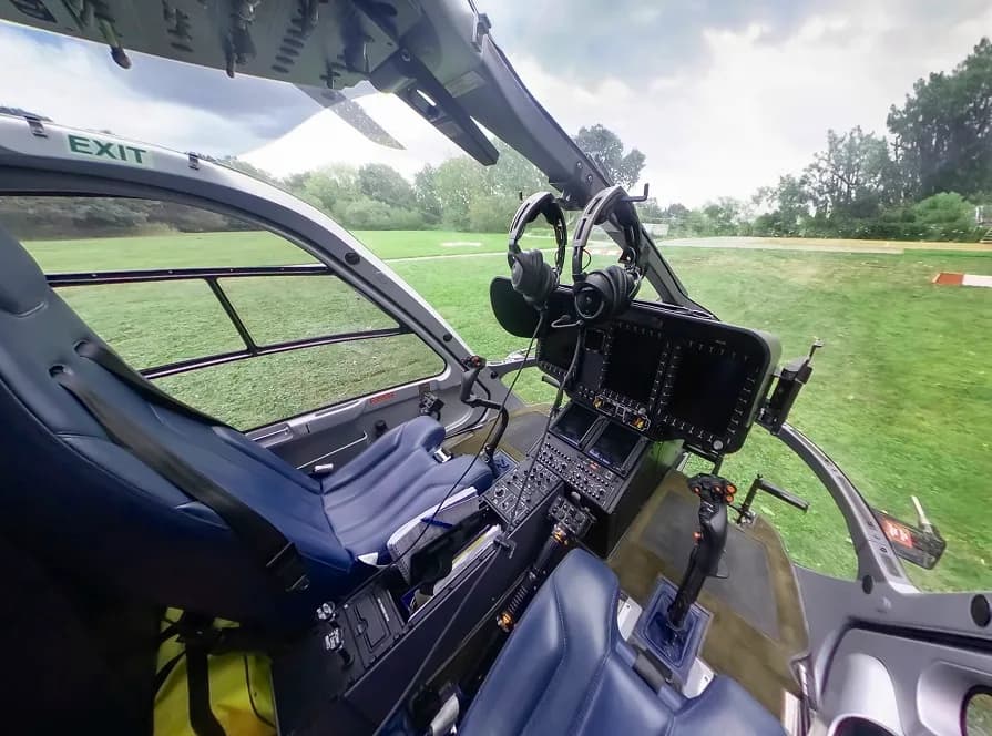 View of the helicopter cockpit with instrument panel and controls.