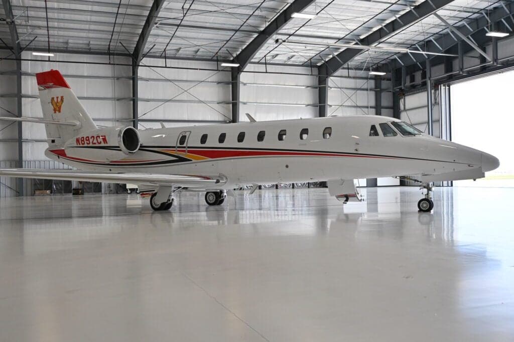 A Citation Sovereign aircraft with tail number N892CW is parked in a hangar.