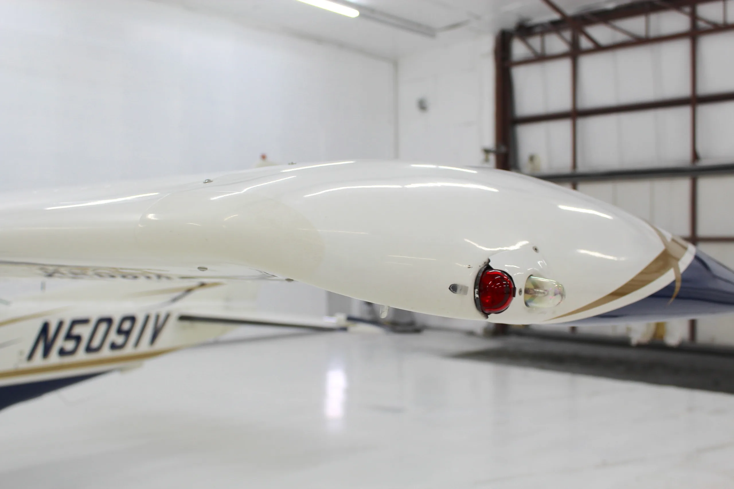 Close-up of the red navigation light on the wingtip of the Cessna 206 aircraft, N5091V.