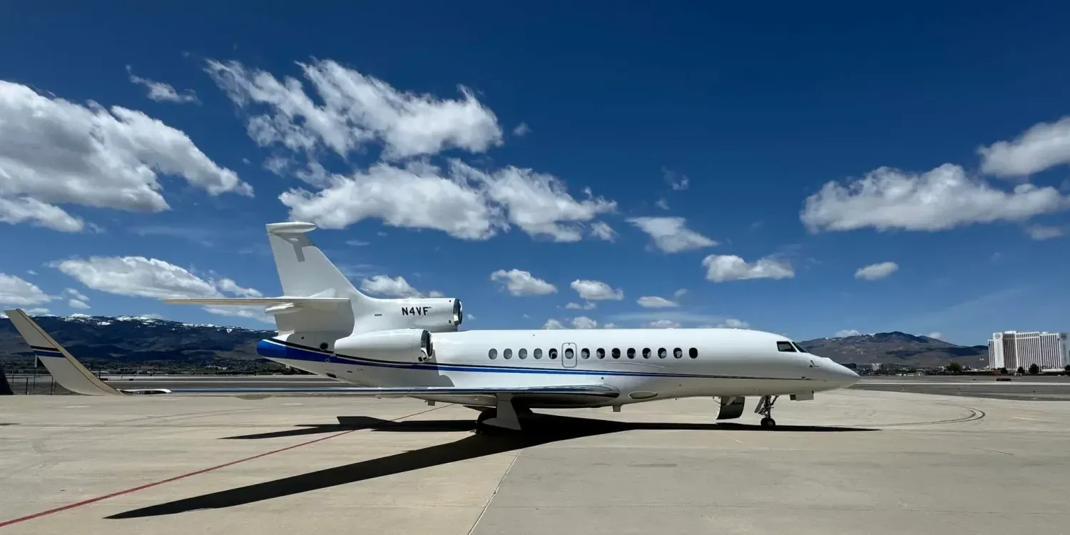 Side view of a white Falcon aircraft on the tarmac.