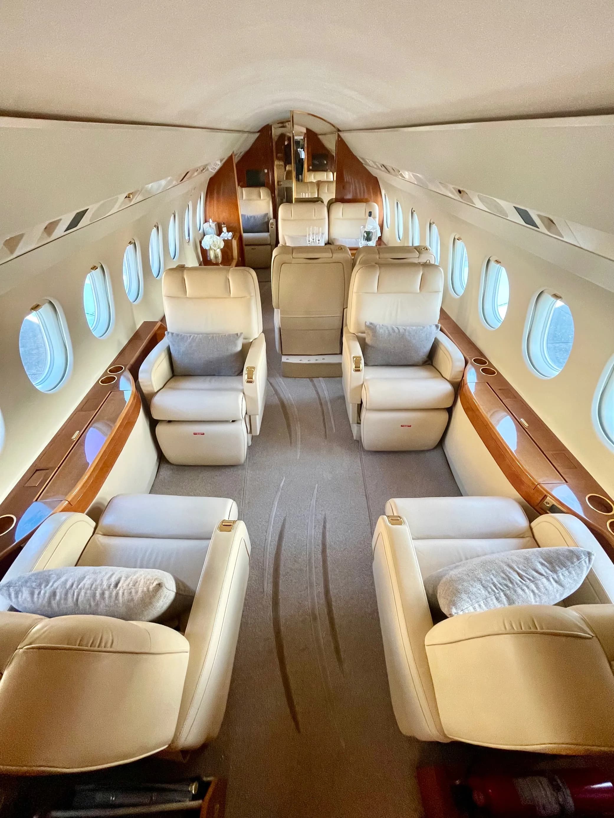 Forward view of the aircraft interior with cream-colored leather seats.