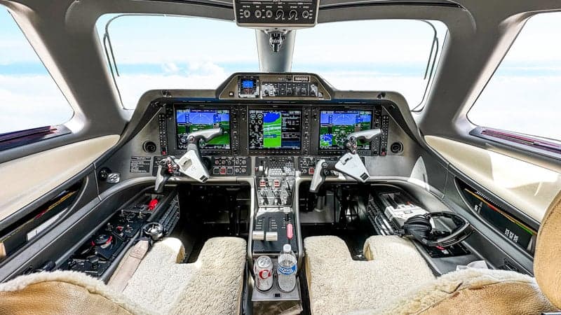 The cockpit of the Phenom 100 aircraft features advanced avionics and comfortable seating.