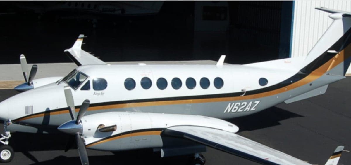 Side view of the N62AZ King Air aircraft with a white and gray paint scheme.