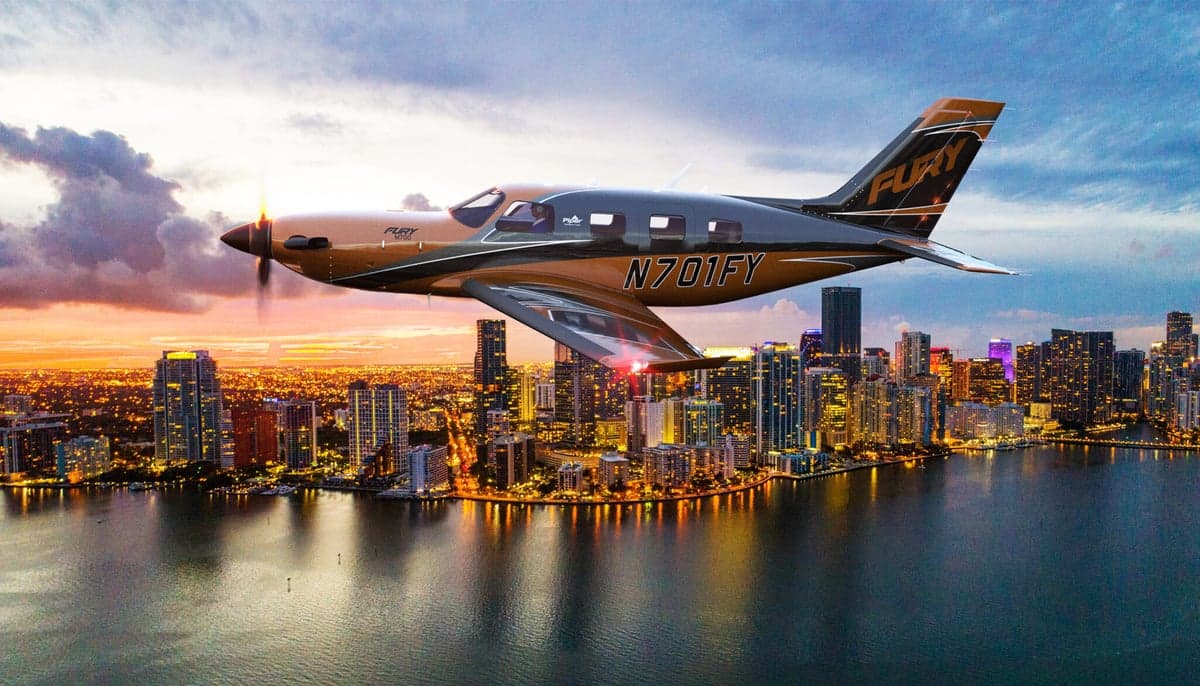 A Fury aircraft flying over a city at sunset.