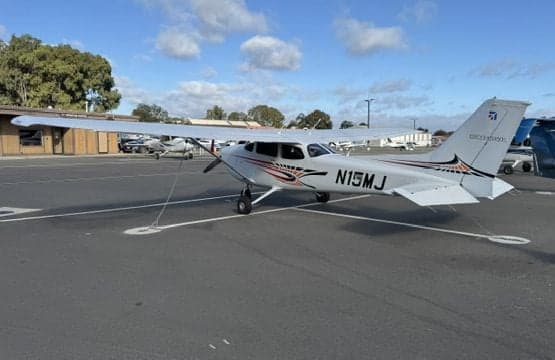 Cessna 172 Skyhawk N15MJ parked on the tarmac with tie-downs.