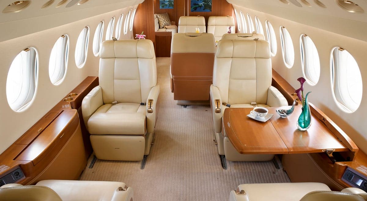 View of the aircraft's interior with seating, tables, and refreshments.