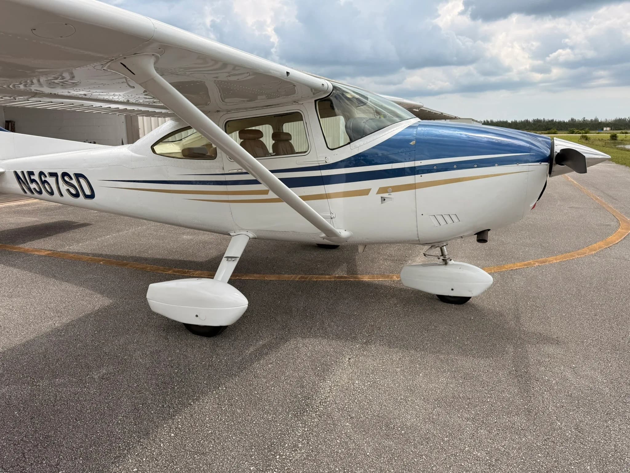 A side view of the front fuselage of the Cessna Skylane N567SD, showing the engine cowling and landing gear.