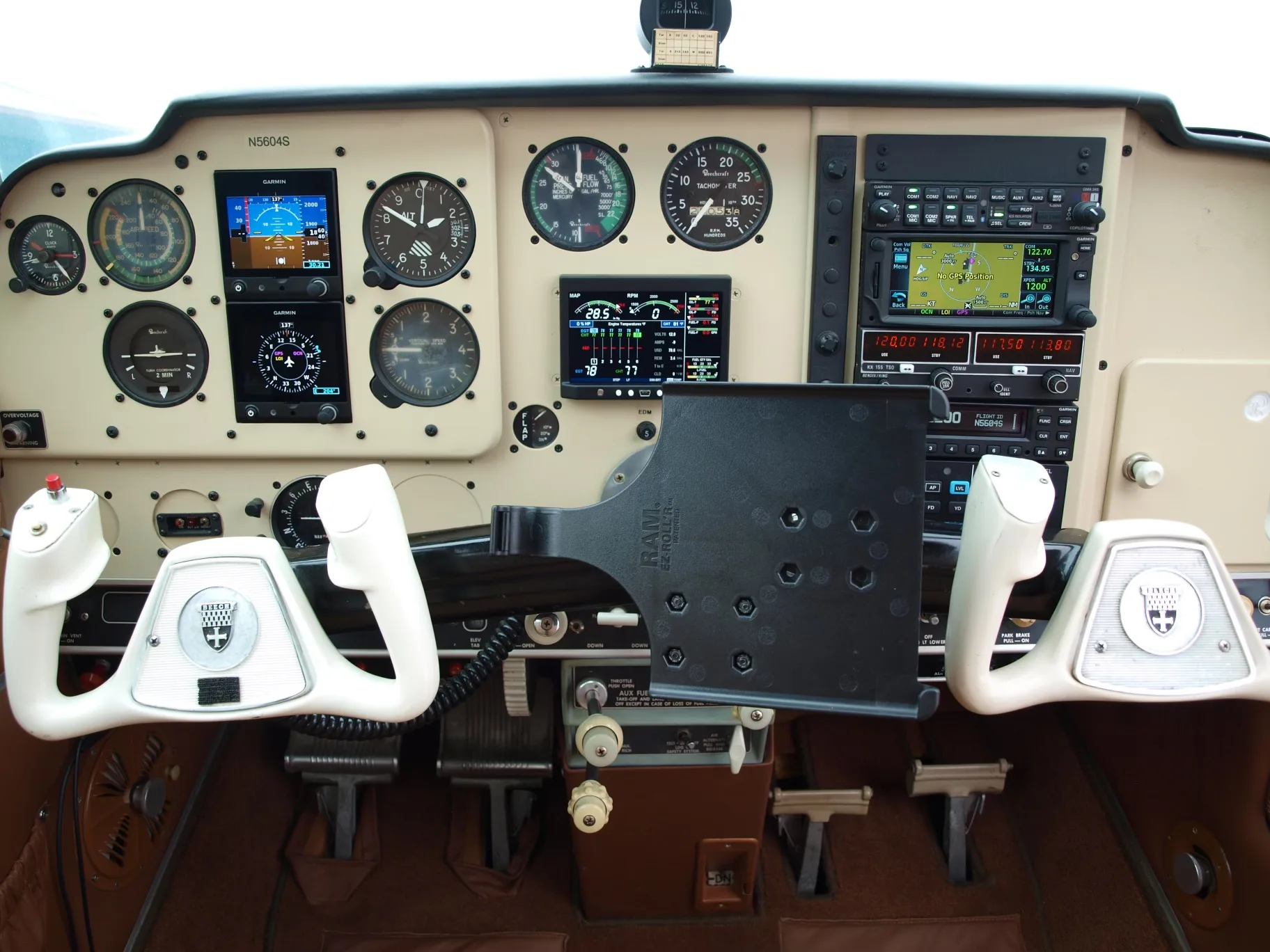 The cockpit of a Beechcraft V35 Bonanza aircraft, featuring the instrument panel and control yokes.