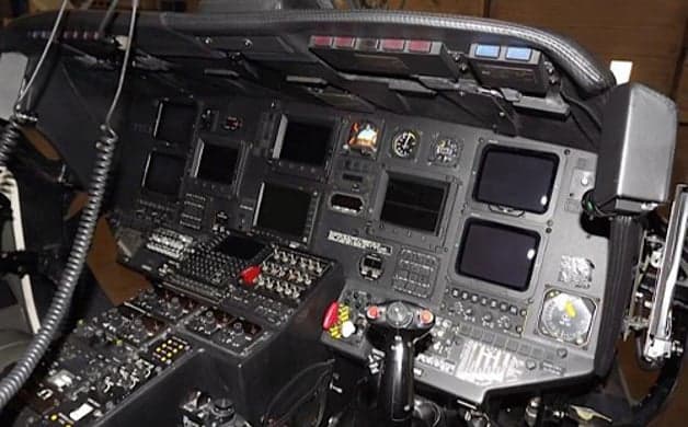 Interior view of the helicopter with leather seats and a table with drinks.