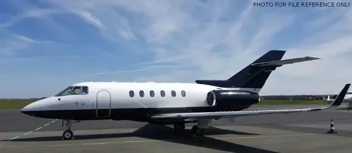 A black and white jet aircraft is parked on the tarmac.