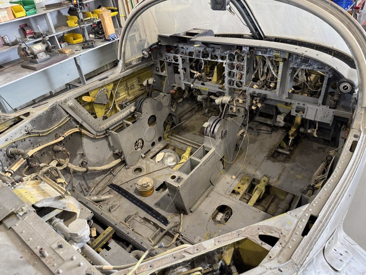 The cockpit of an aircraft undergoing restoration, showing the instrument panel and controls.