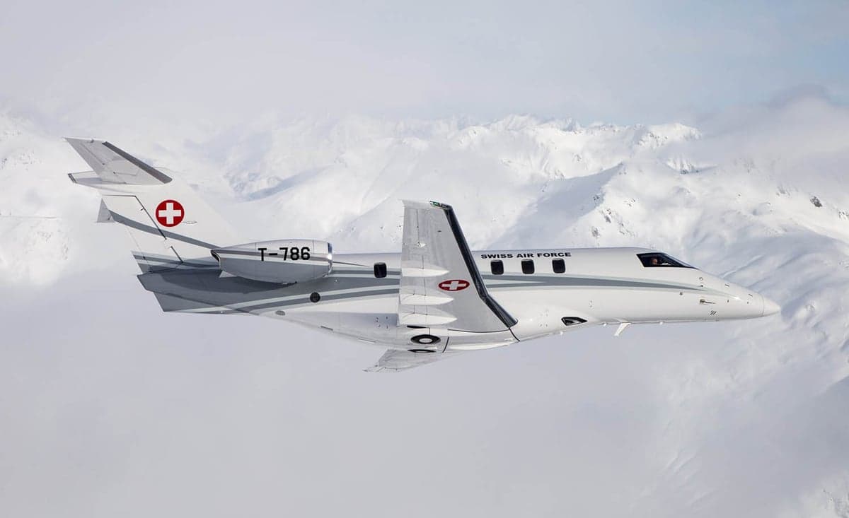 A Pilatus PC-24 flying over a snowy mountain range.