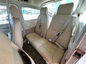 A view of the Cessna 182 Skylane interior, showing the rear seats and side panels.