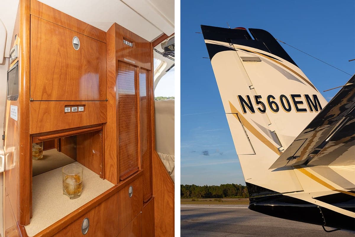 Interior cabinet with a glass of whiskey and the tail of the aircraft with the registration N560EM.