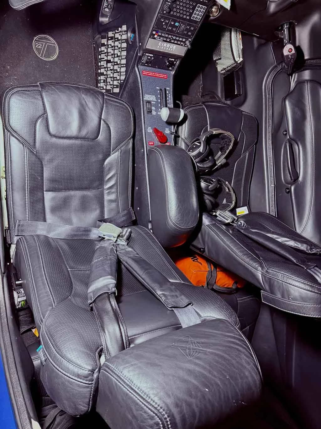 The black leather pilot and co-pilot seats and center console of a Cirrus SR22T cockpit.