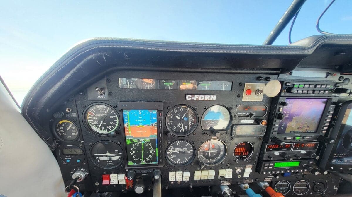 A close-up view of a Mooney M20J cockpit with analog gauges and modern digital displays.