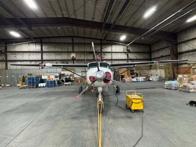 Front view of a turboprop aircraft parked inside a hangar.