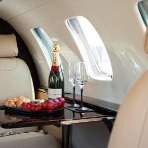 Interior of a Cessna Citation CJ1+ with a table set with champagne and snacks.