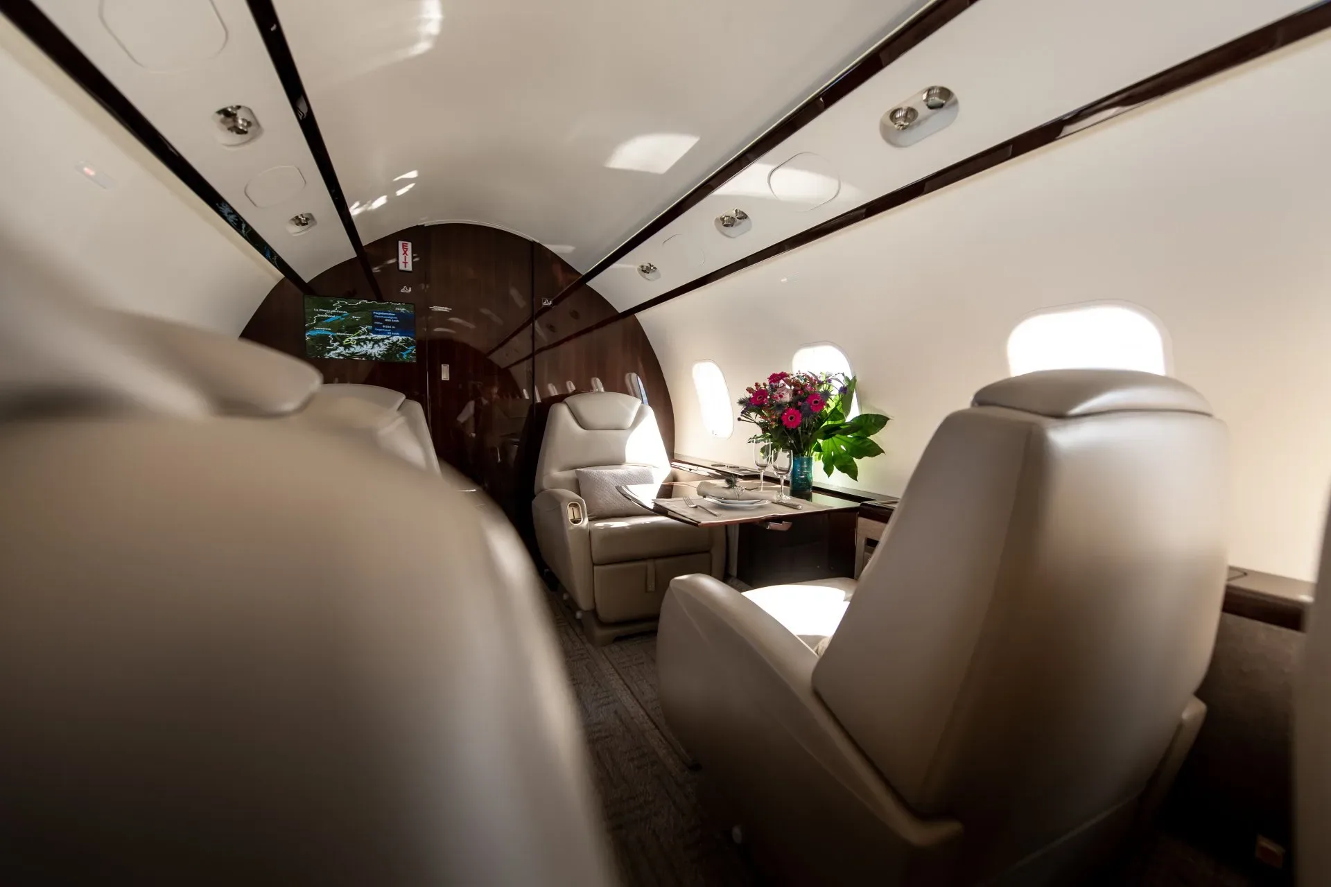 A view of the aircraft's interior with leather seats and a table with flowers.